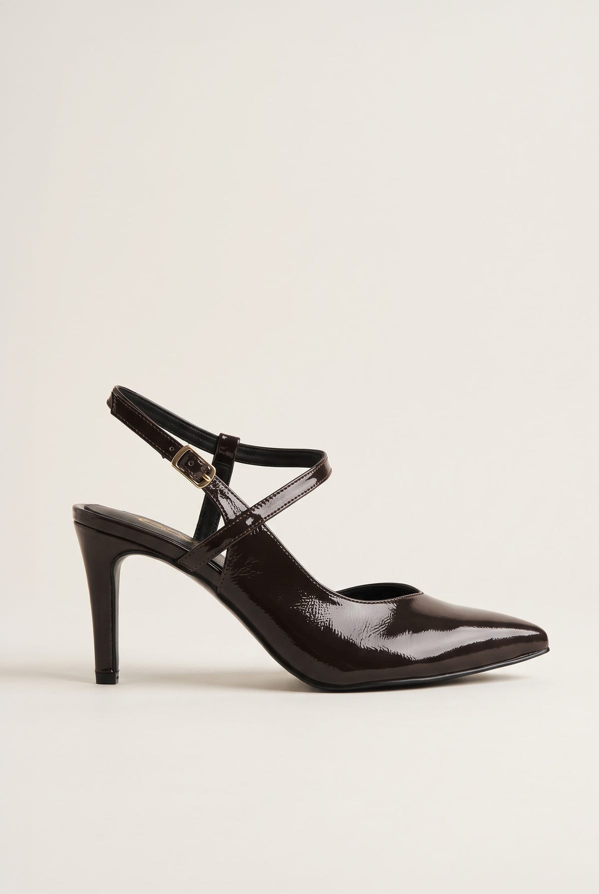 Side view of a single brown patent slingback pump with crossed ankle straps and slim high heel