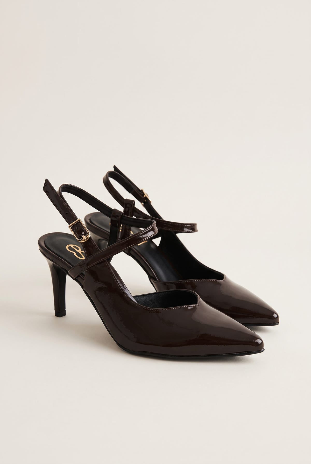 Pair of brown patent slingback pumps in side view with pointed toes and buckled ankle straps