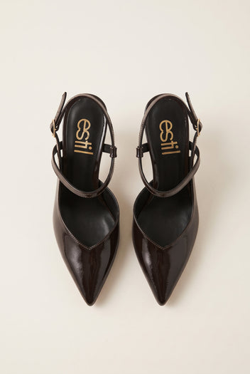 Top view of a pair of brown patent slingback pumps with pointed toes and buckled ankle straps