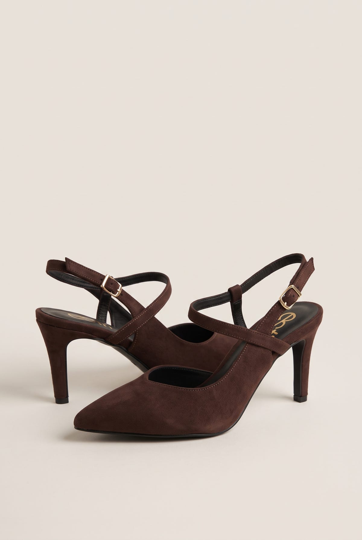 Angled pair of brown suede pointed toe slingback pumps with buckled ankle straps and slim heels
