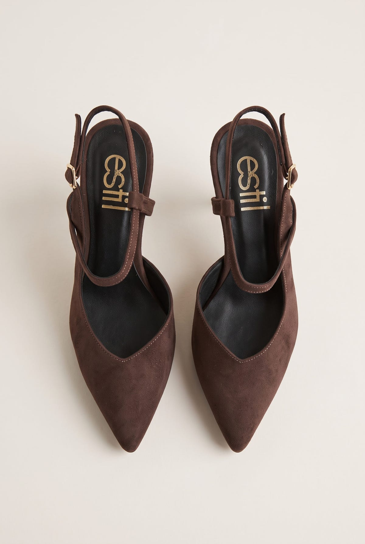 Top view of brown suede pointed slingback pumps with narrow ankle straps and small gold buckles