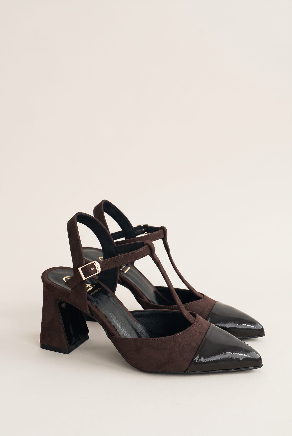 Pair of chocolate suede block heel pumps with black patent toe caps and T-straps, angled three-quarter view