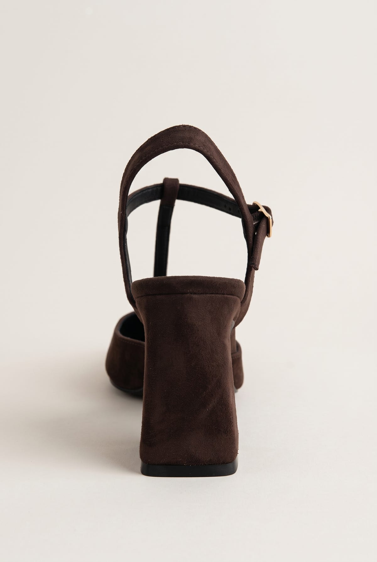 Back view of chocolate suede block heel pump with T-strap and buckle closure at the ankle
