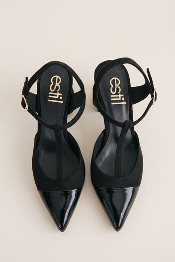 Top view of black T-strap pumps with suede body, patent pointed toe caps and ankle buckles