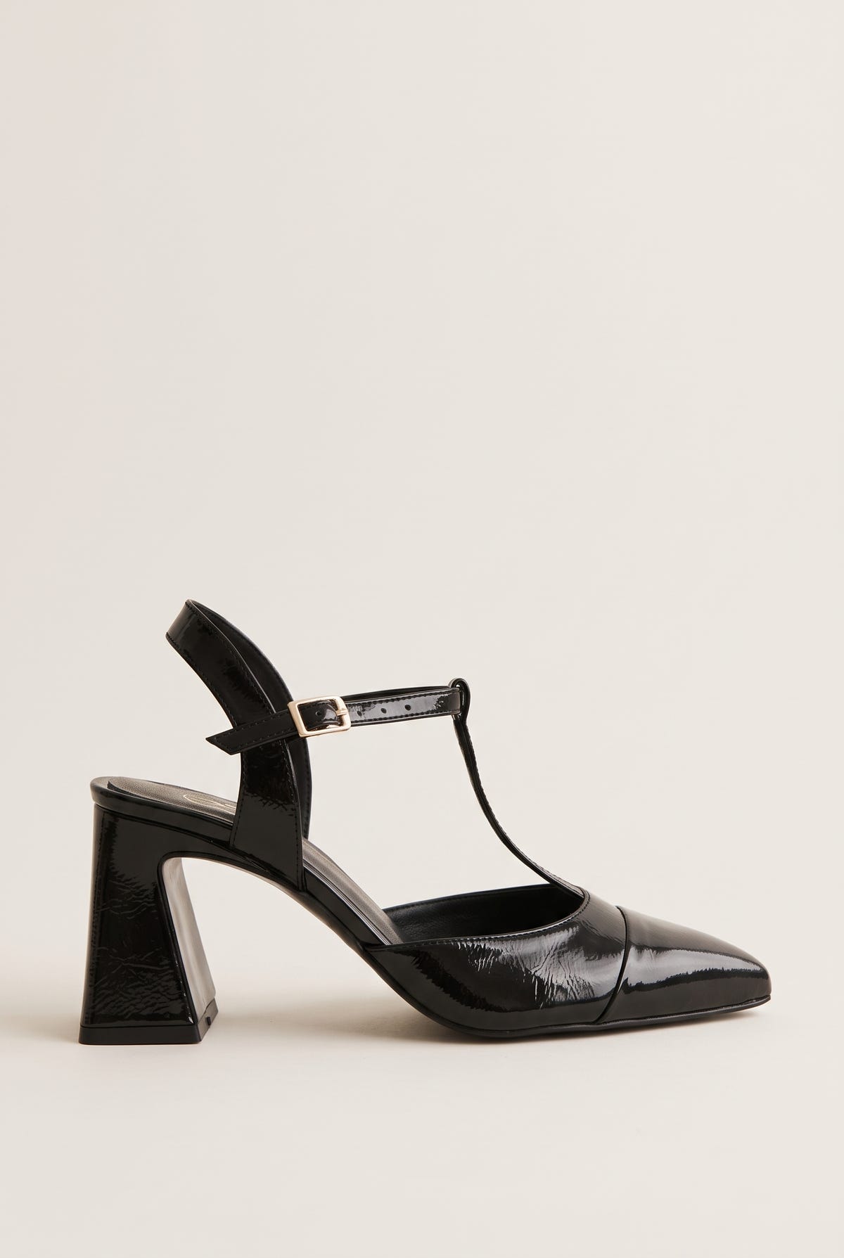 Black patent T-strap pump with pointed toe, ankle strap buckle and flared block heel in side view