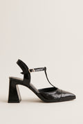 Black patent T-strap pump with pointed toe, ankle strap buckle and flared block heel in side view