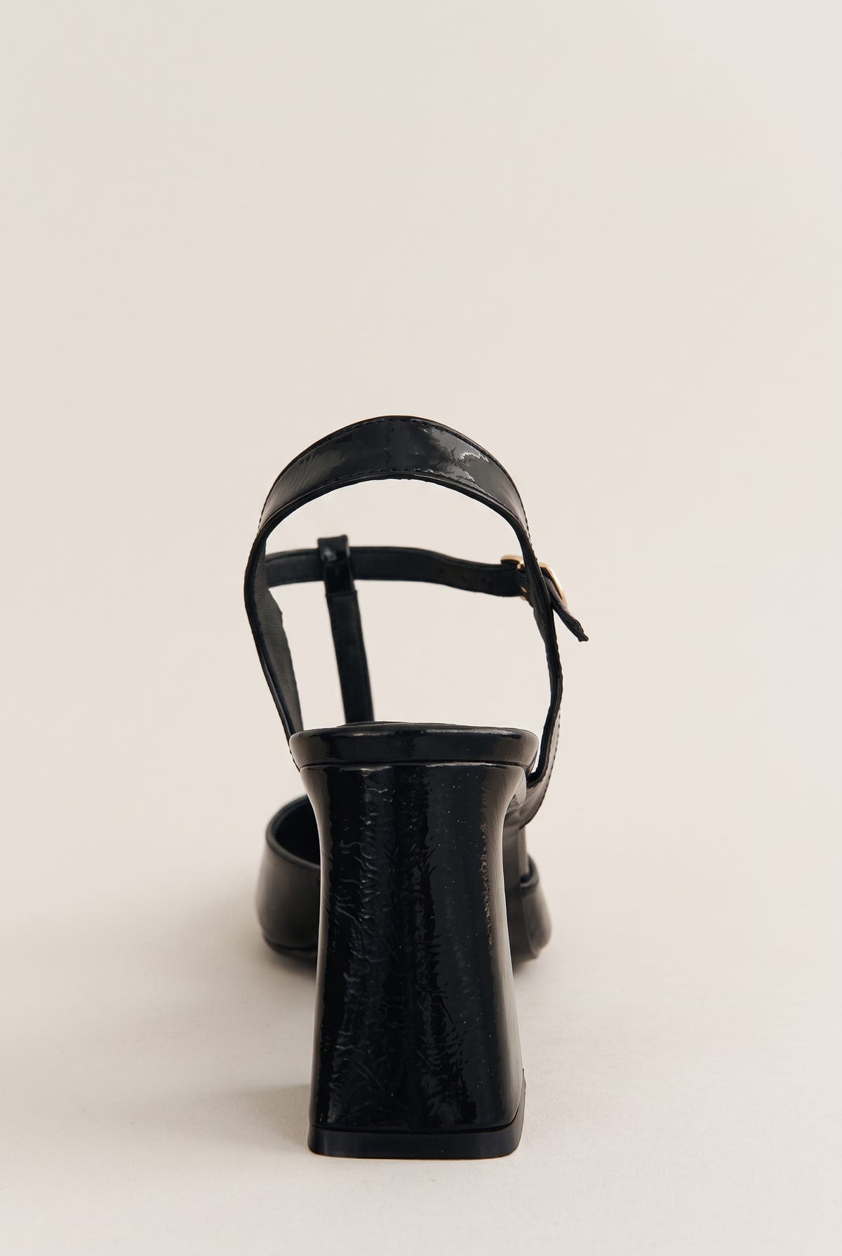 Black patent T-strap pump in rear view showing ankle strap, flared block heel and back counter