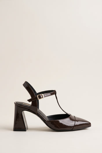 Brown patent T-strap pump with pointed toe, ankle strap buckle and flared block heel in side view
