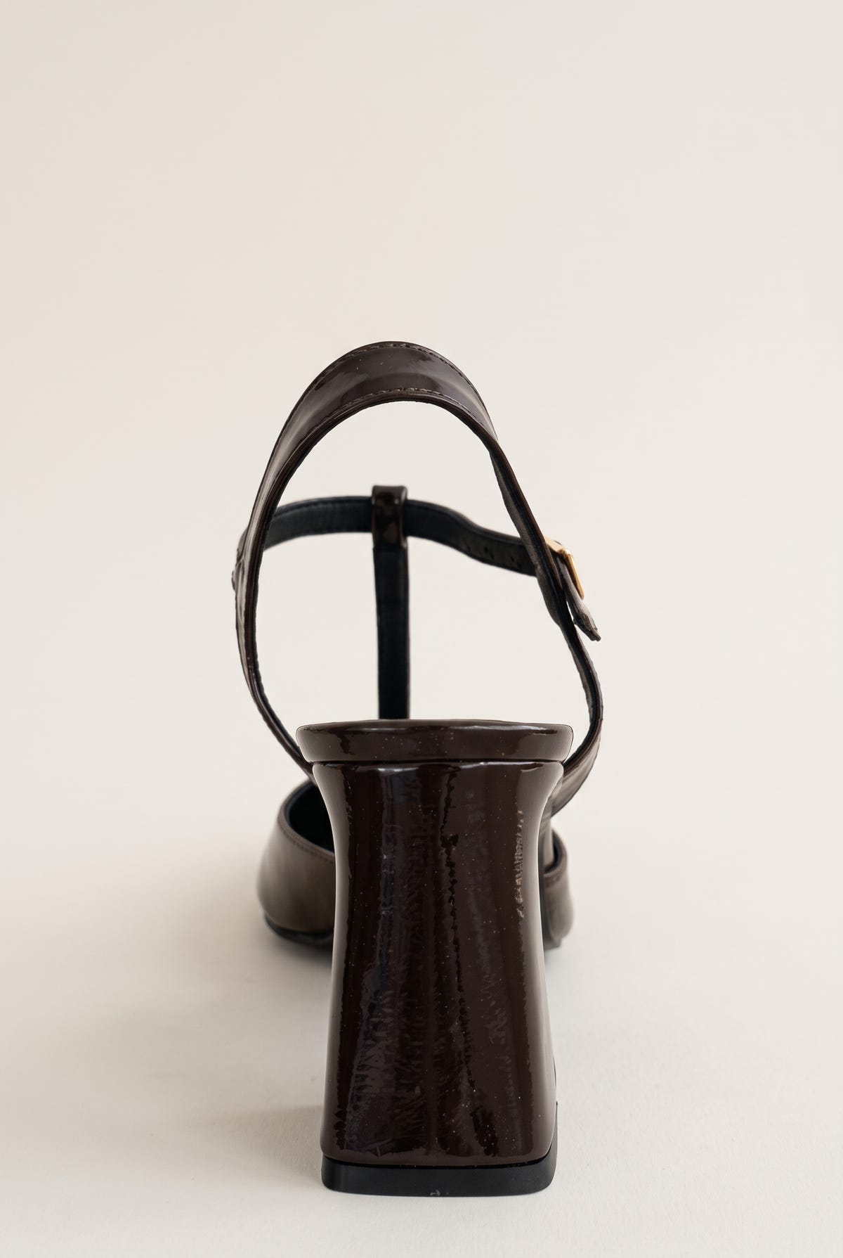 Brown patent block heel pump with T-strap ankle strap and slim buckle, seen from the back view