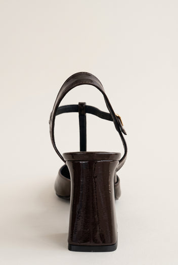 Brown patent block heel pump with T-strap ankle strap and slim buckle, seen from the back view