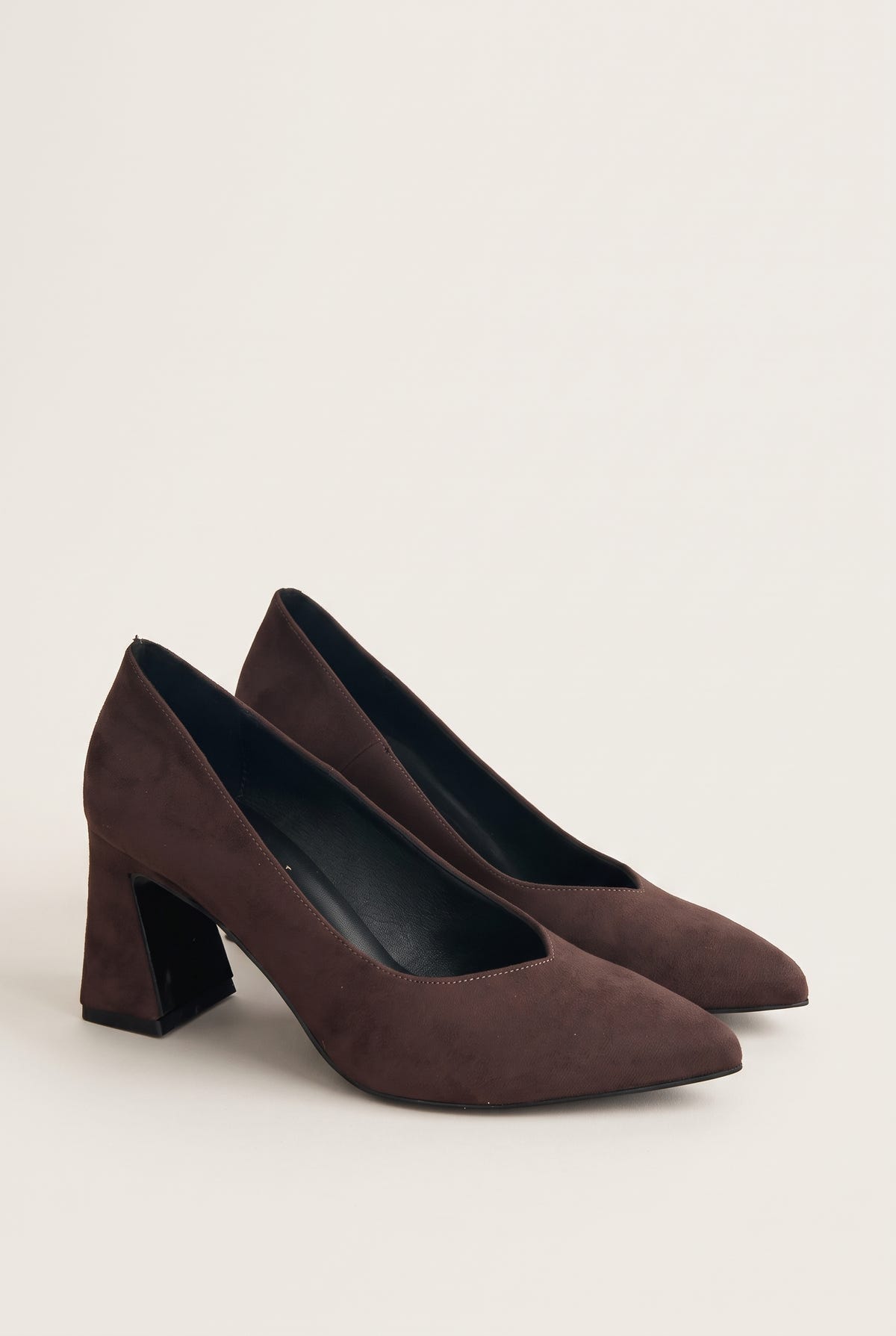 Pair of brown suede pointed-toe pumps in three-quarter view showing matte nap and block heels