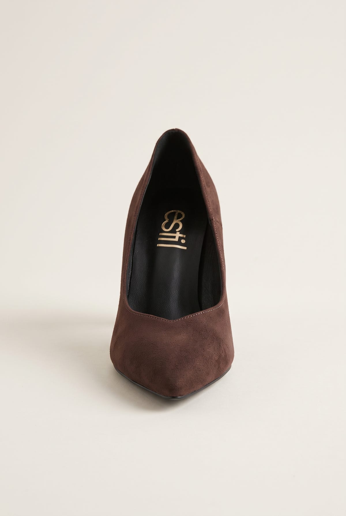 Brown suede pump seen from the front showing narrow pointed toe and tapered vamp