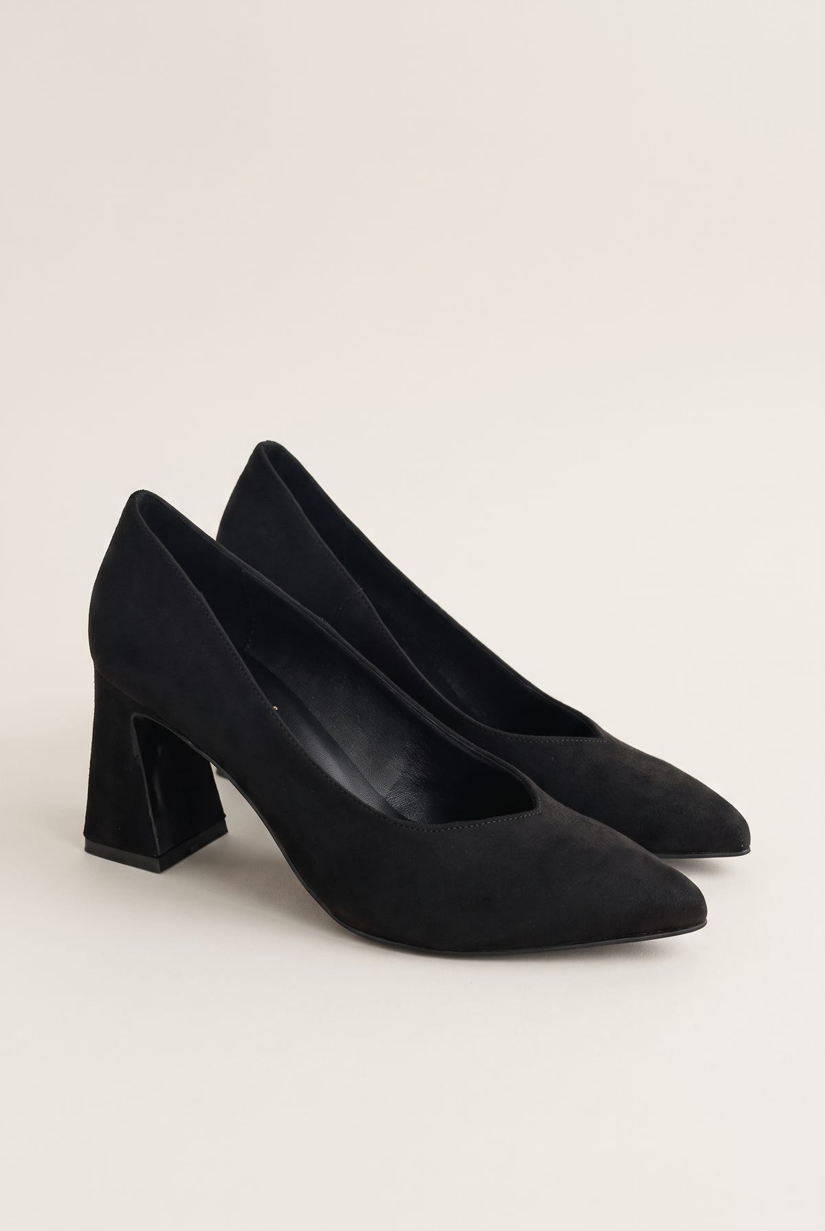 Pair of black suede pointed-toe pumps in three-quarter view showing matte nap and flared heels