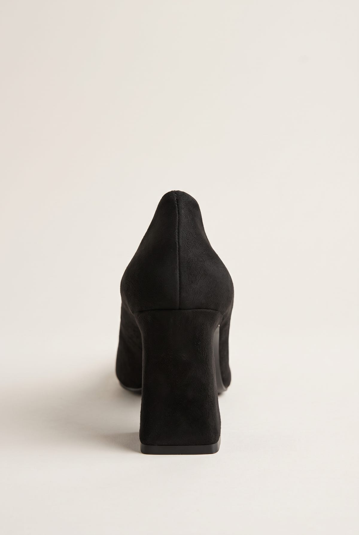Rear view of black suede pump showing flared block heel, smooth back counter and sleek matte finish