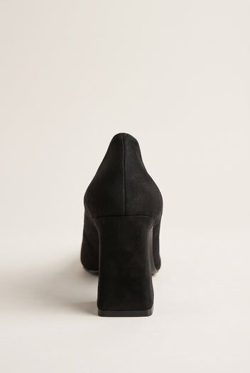 Rear view of black suede pump showing flared block heel, smooth back counter and sleek matte finish