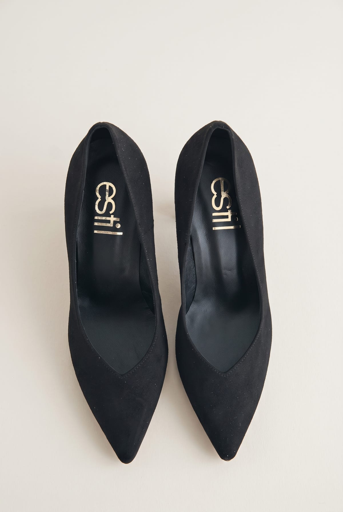 Top view of black suede pointed-toe pumps showing narrow tapered toes and padded insole