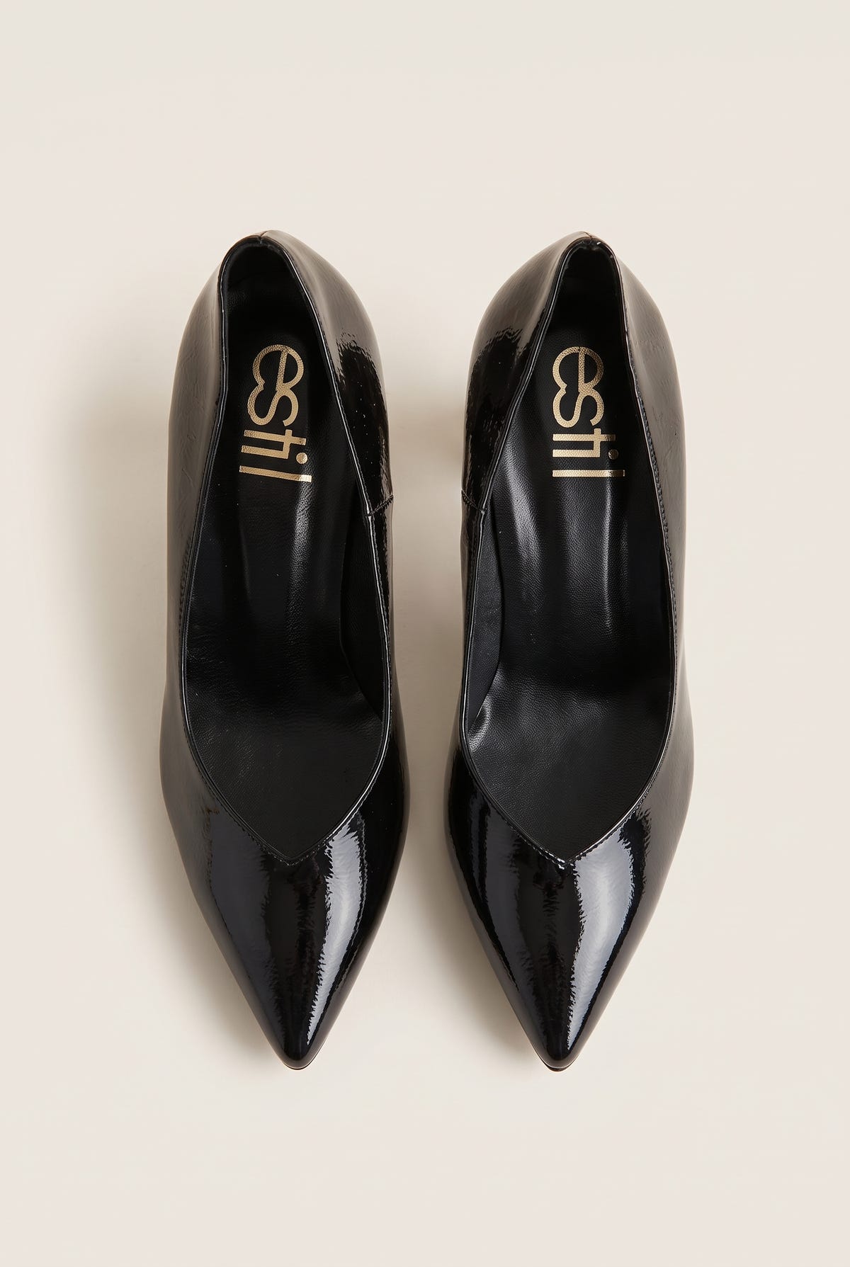 Top view of black patent pointed-toe pumps showing narrow toe shape and padded black insole