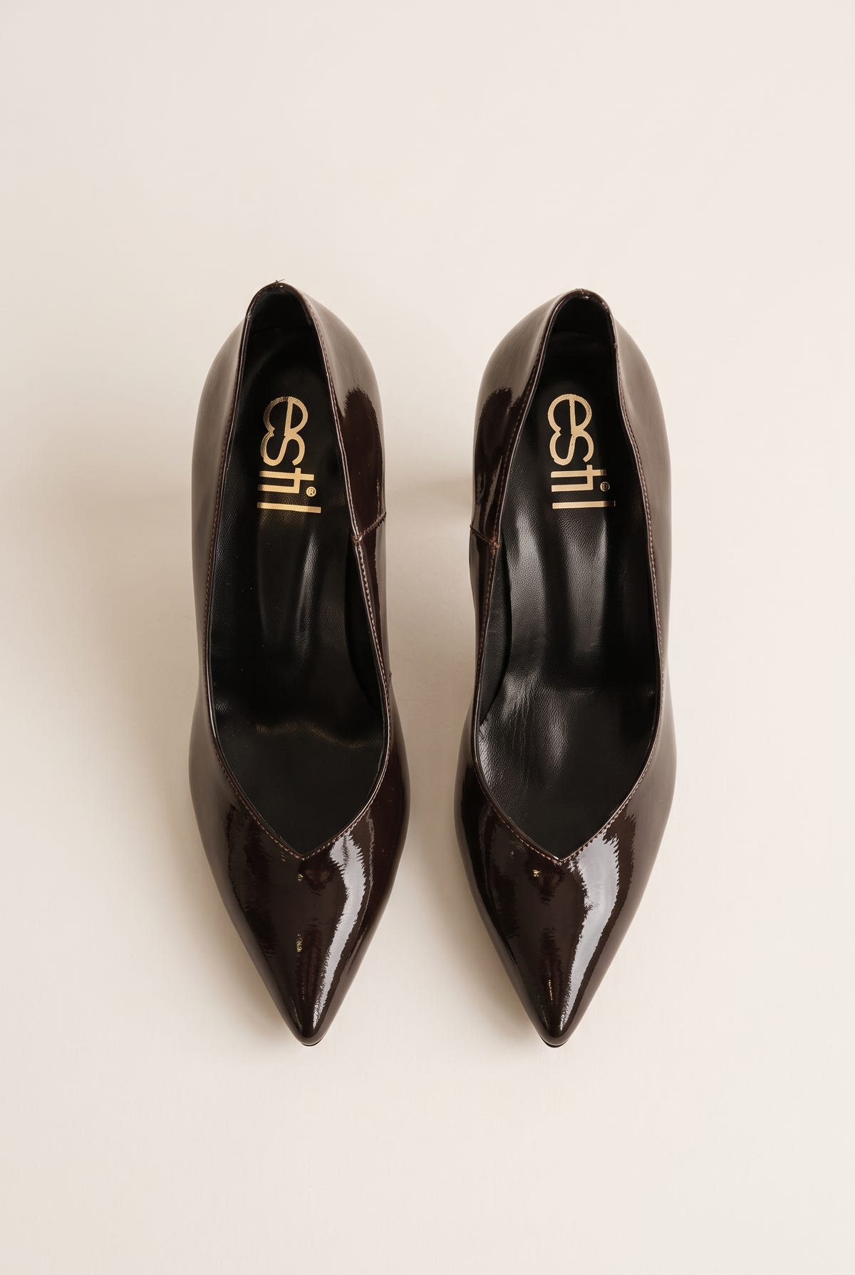 Top view of brown patent pointed-toe pumps showing narrow toe shape and padded insole
