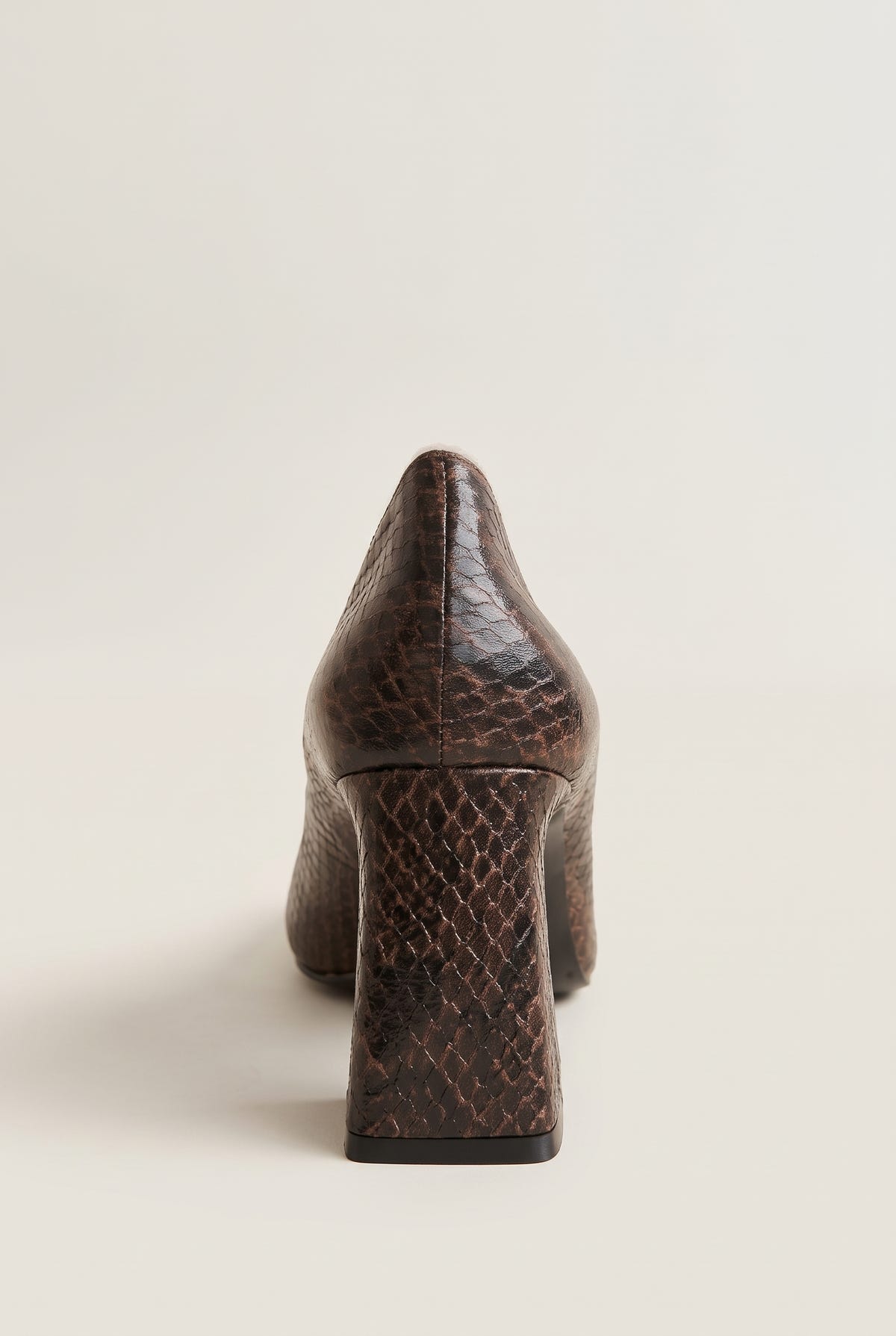 Rear view of brown snake-print pump showing textured back counter and flared block heel