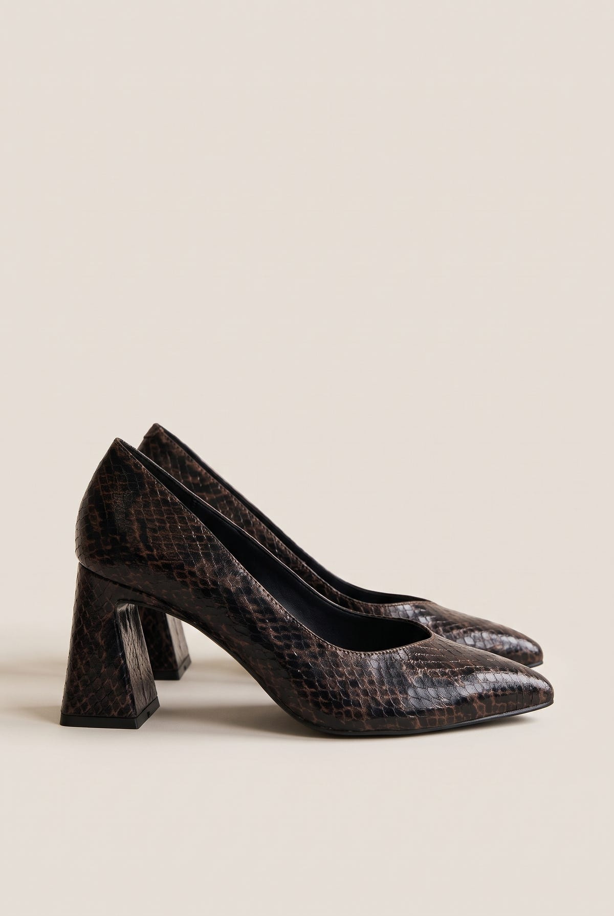 Pair of brown snake-print pointed-toe pumps in angled view showing flared block heels