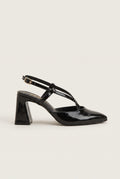 Side view of glossy black patent block heel slingback with crossed straps and pointed toe