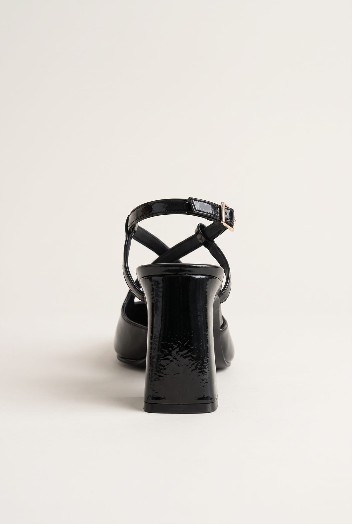 Rear view of glossy black patent block heel slingback with ankle strap buckle and sturdy heel