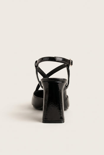 Back view of a brown patent slingback pump showing the narrow crossed straps at the heel counter and the tall block heel