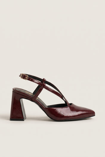 Side view of bordeaux patent block heel slingback with crossed straps and pointed toe