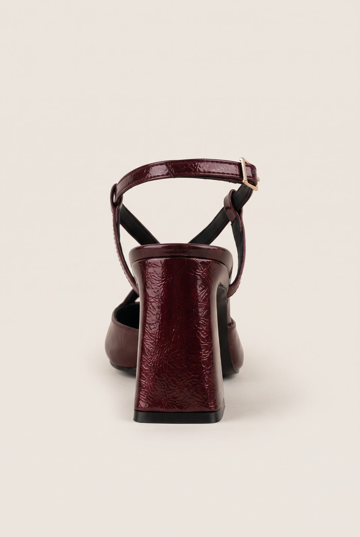 Rear view of bordeaux patent slingback with ankle strap buckle and sturdy block heel