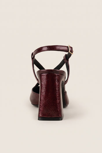 Rear view of bordeaux patent slingback with ankle strap buckle and sturdy block heel