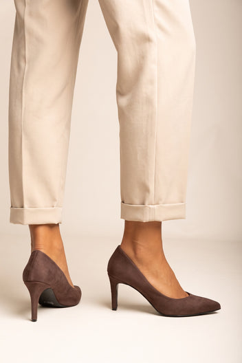 Model wearing brown suede pointed pumps with cream cuffed trousers seen from the side