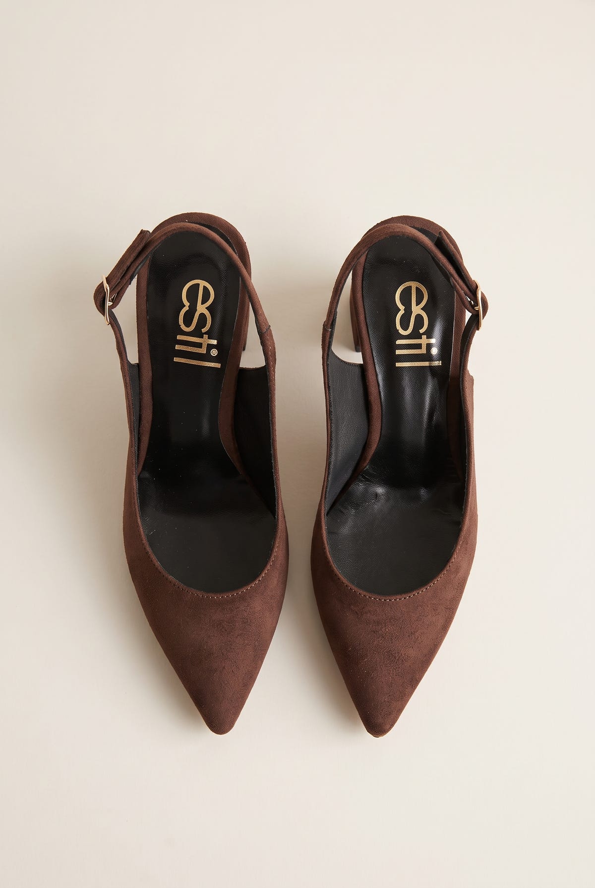 Top view of a pair of brown suede slingback pumps with pointed toes, dark insoles and slim straps lying open