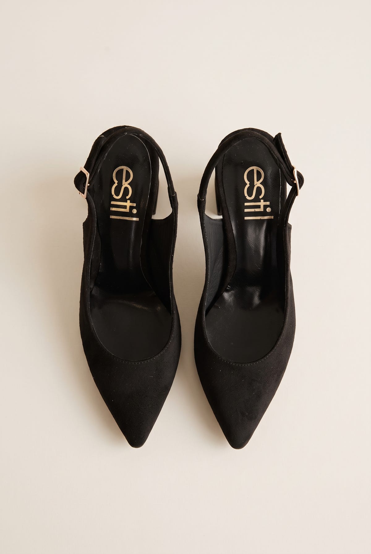 Top view of a pair of black suede slingback pumps showing pointed toes, dark insoles and the sides of the heels