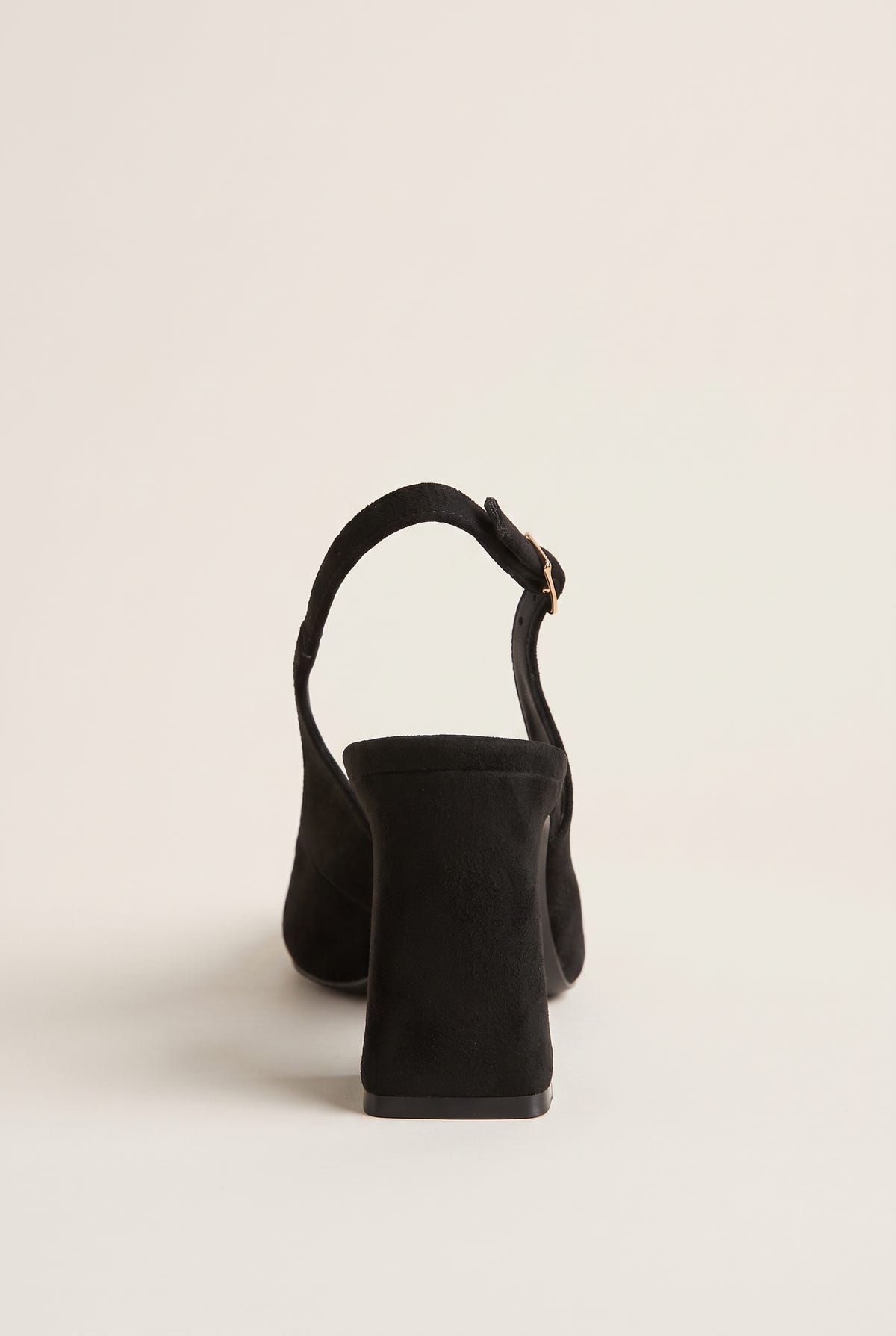 Back view of a black suede slingback pump showing its block heel, heel counter and slim buckled strap