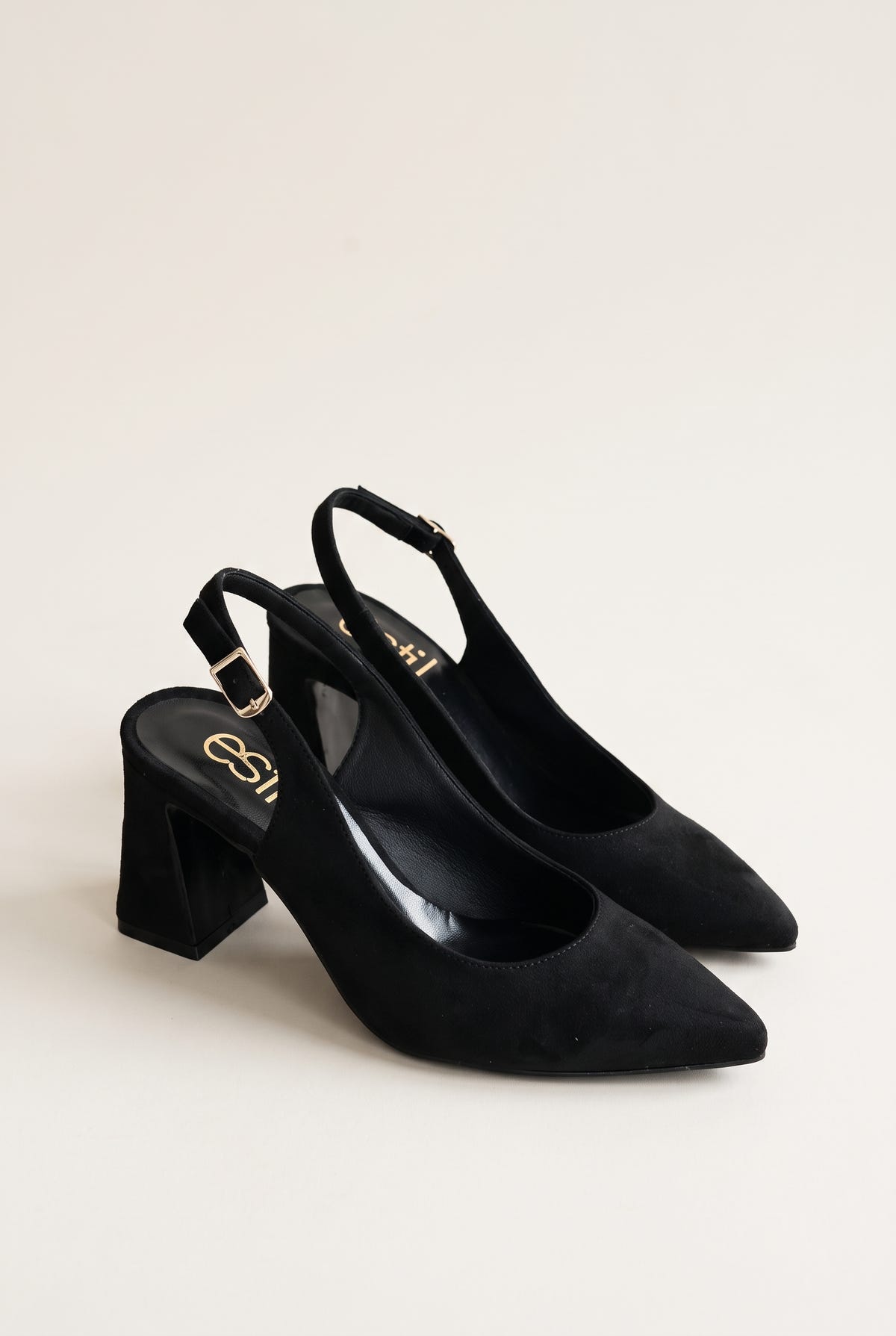 Pair of black suede slingback pumps with pointed toes and block heels, turned slightly to show both shoes on white