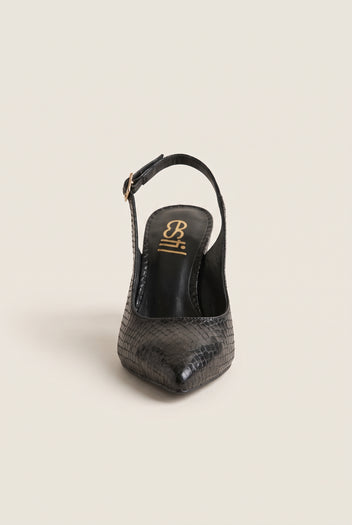 Front view of a black snake-embossed slingback pump with a pointed toe and a gold-tone buckle strap resting on its heel