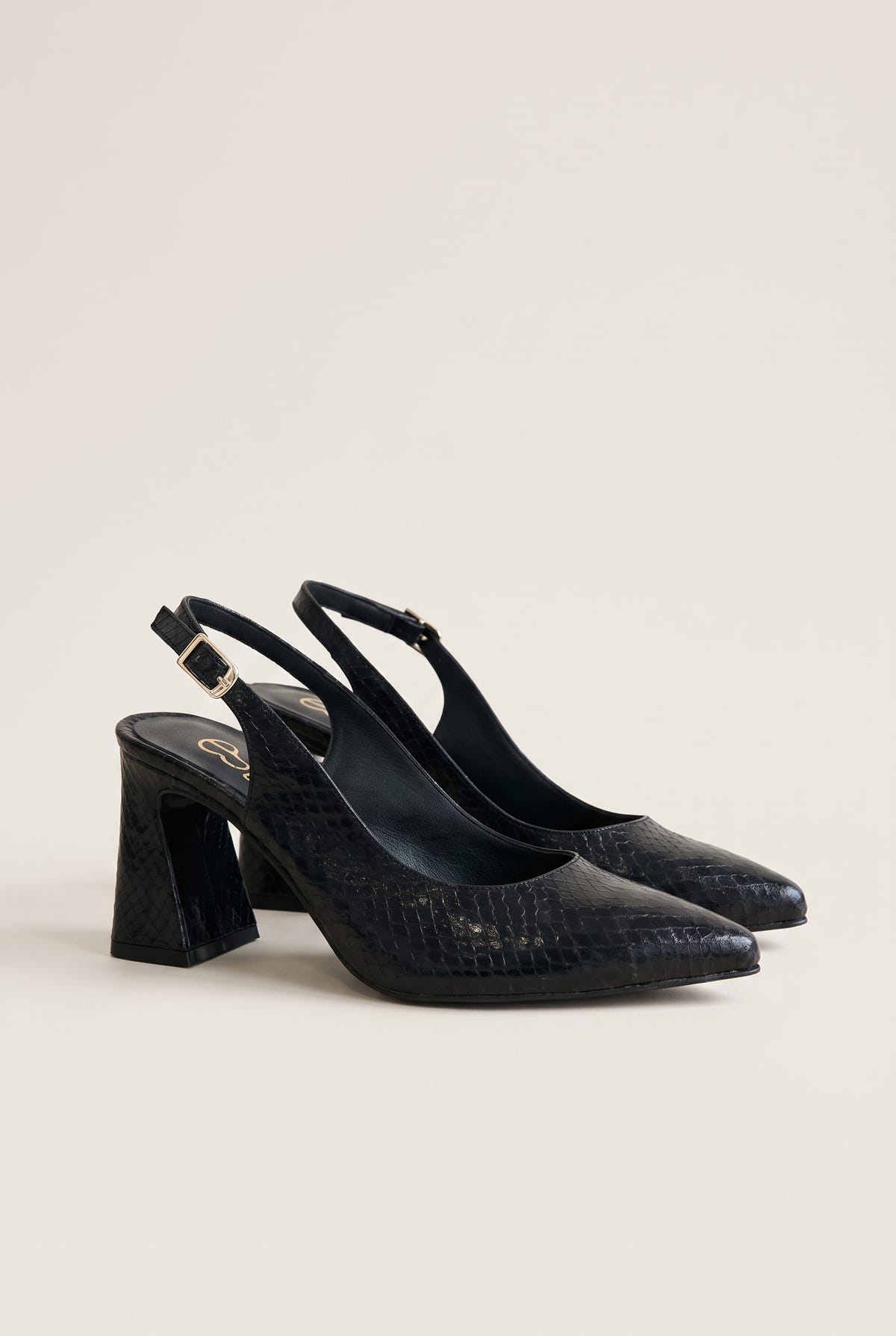 Pair of black snake-embossed pointed-toe slingback pumps with block heels in a side view on a plain white surface