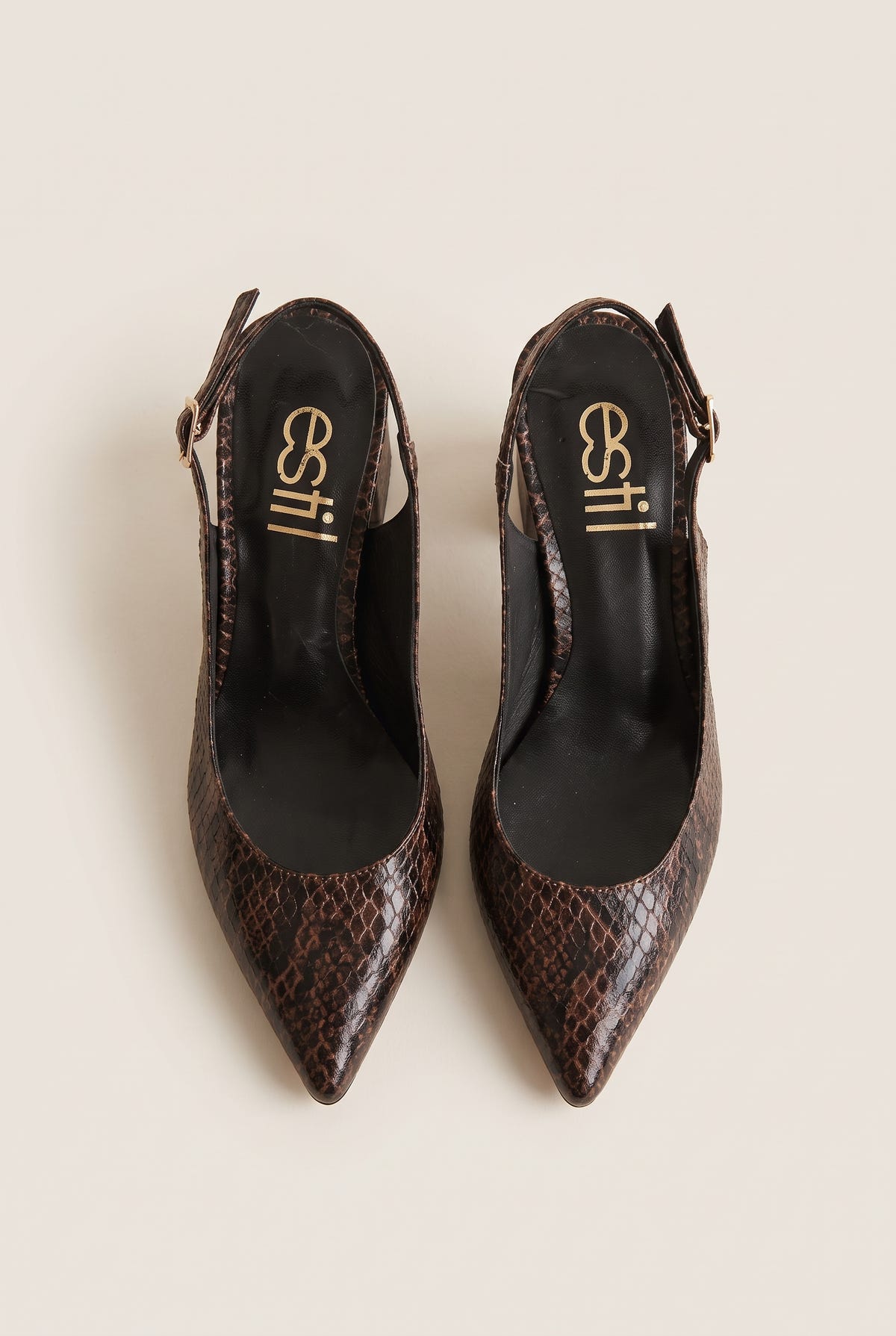 Top view of a pair of brown snake-print slingback pumps with pointed toes and dark interiors resting on a white surface