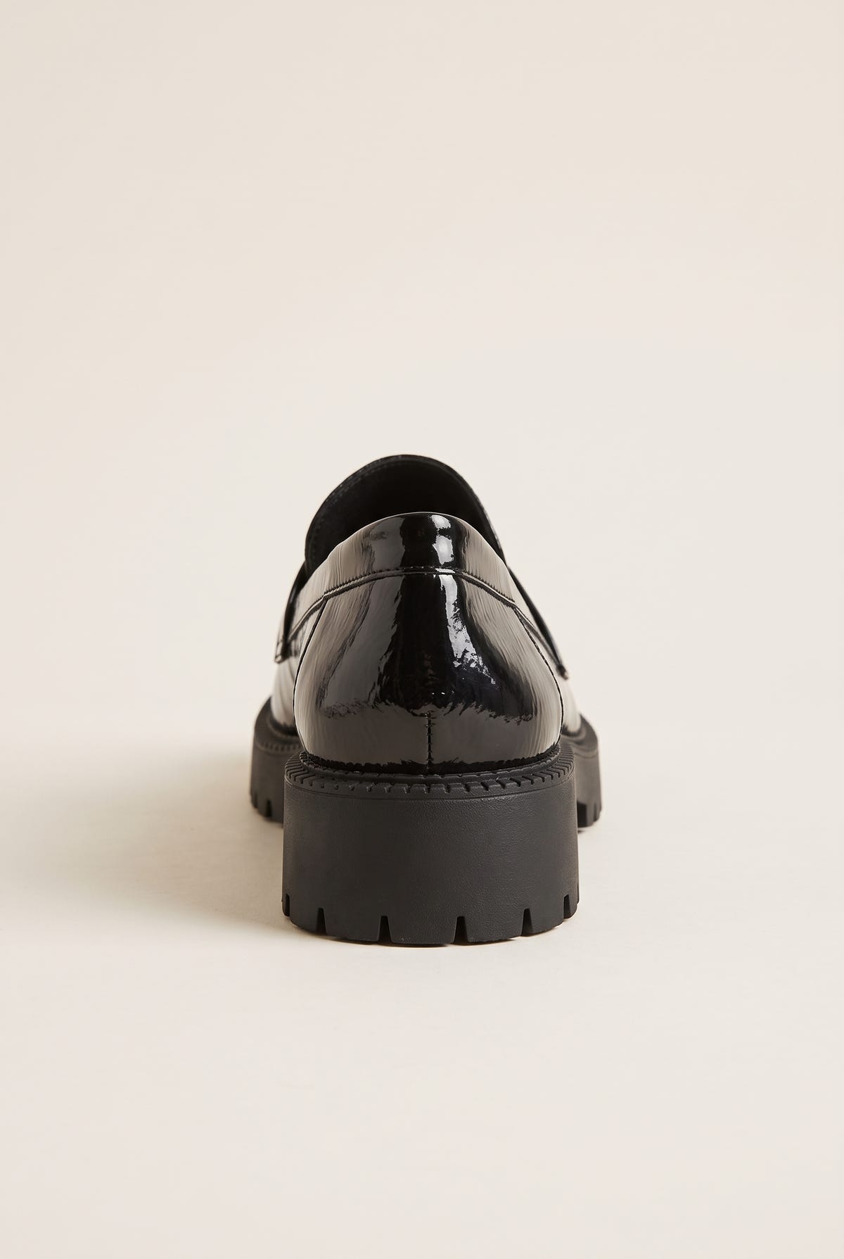 Back view of black patent chunky loafer showing smooth glossy heel counter and lug sole