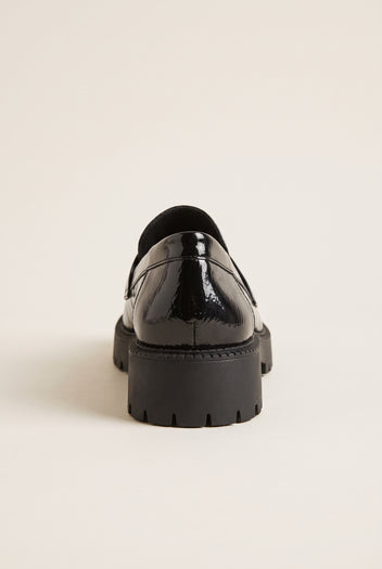 Back view of black patent chunky loafer showing smooth glossy heel counter and lug sole