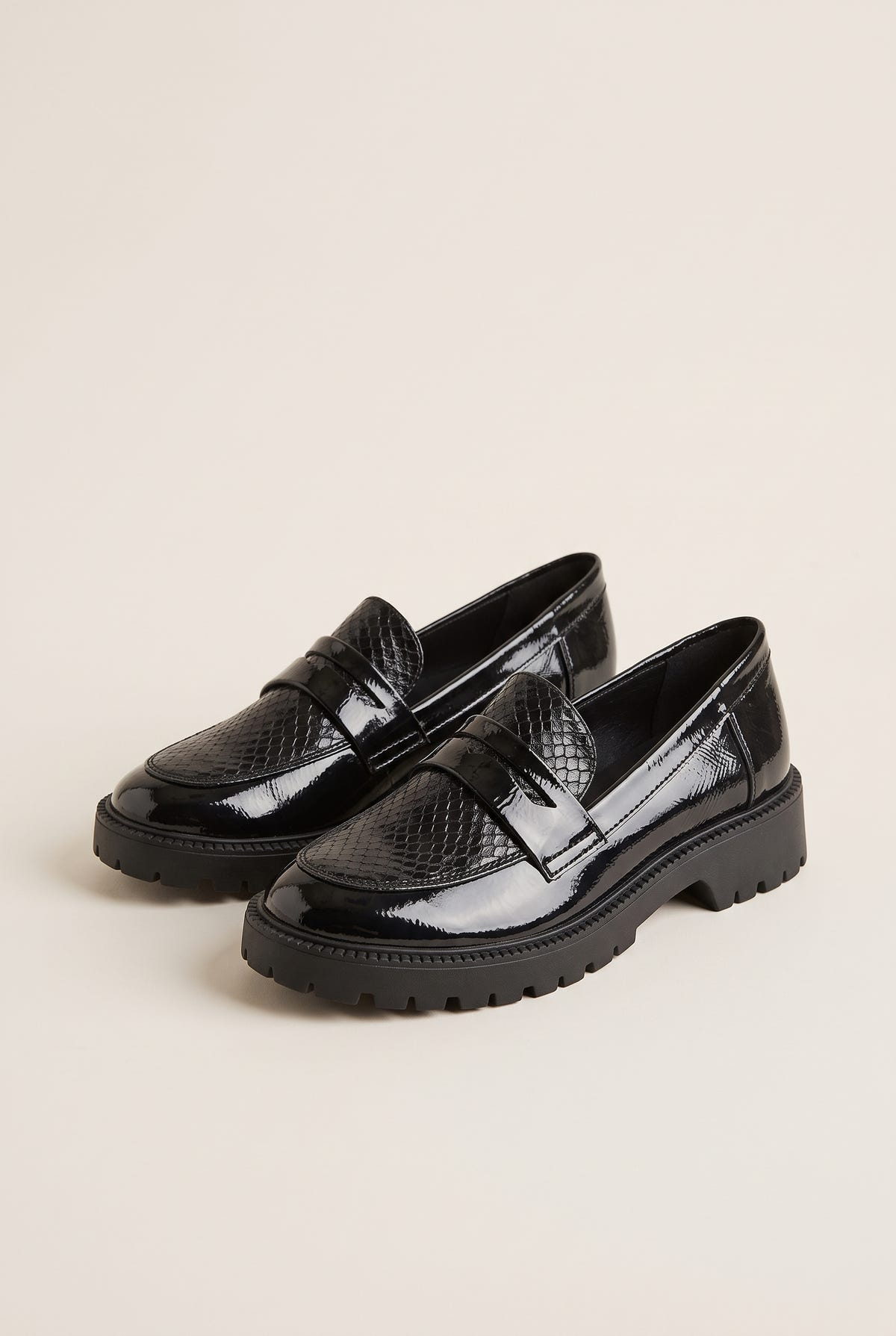 Pair of black patent chunky loafers with snake-embossed penny straps, angled three-quarter view