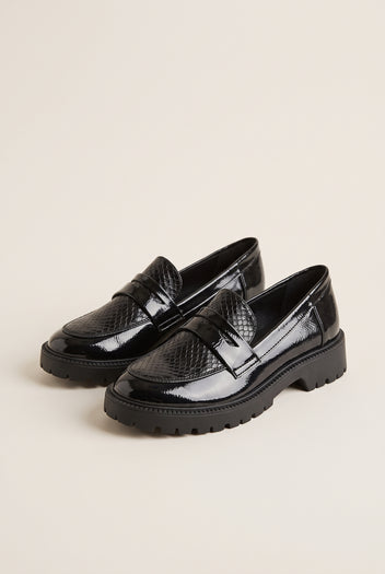 Pair of black patent chunky loafers with snake-embossed penny straps, angled three-quarter view