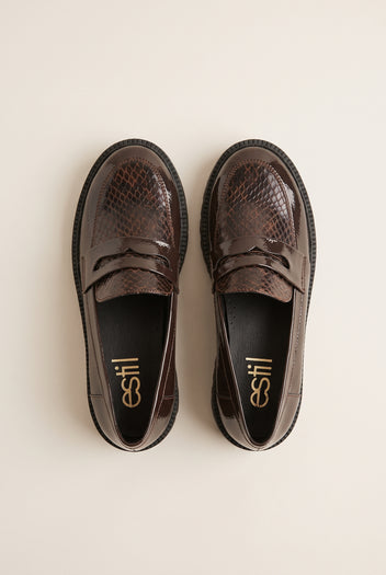 Top view of brown patent snake-embossed chunky loafers placed side by side with penny straps