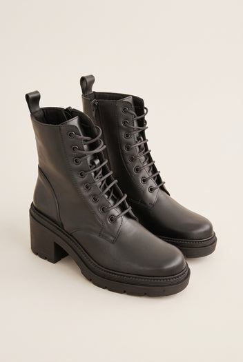 Pair of black leather lace-up ankle boots with side zips, pull tabs and chunky block heels with lug soles, three-quarter view