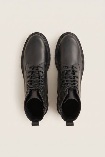 Top-down view of a pair of black leather lace-up boots with black laces, side zips and back pull tabs