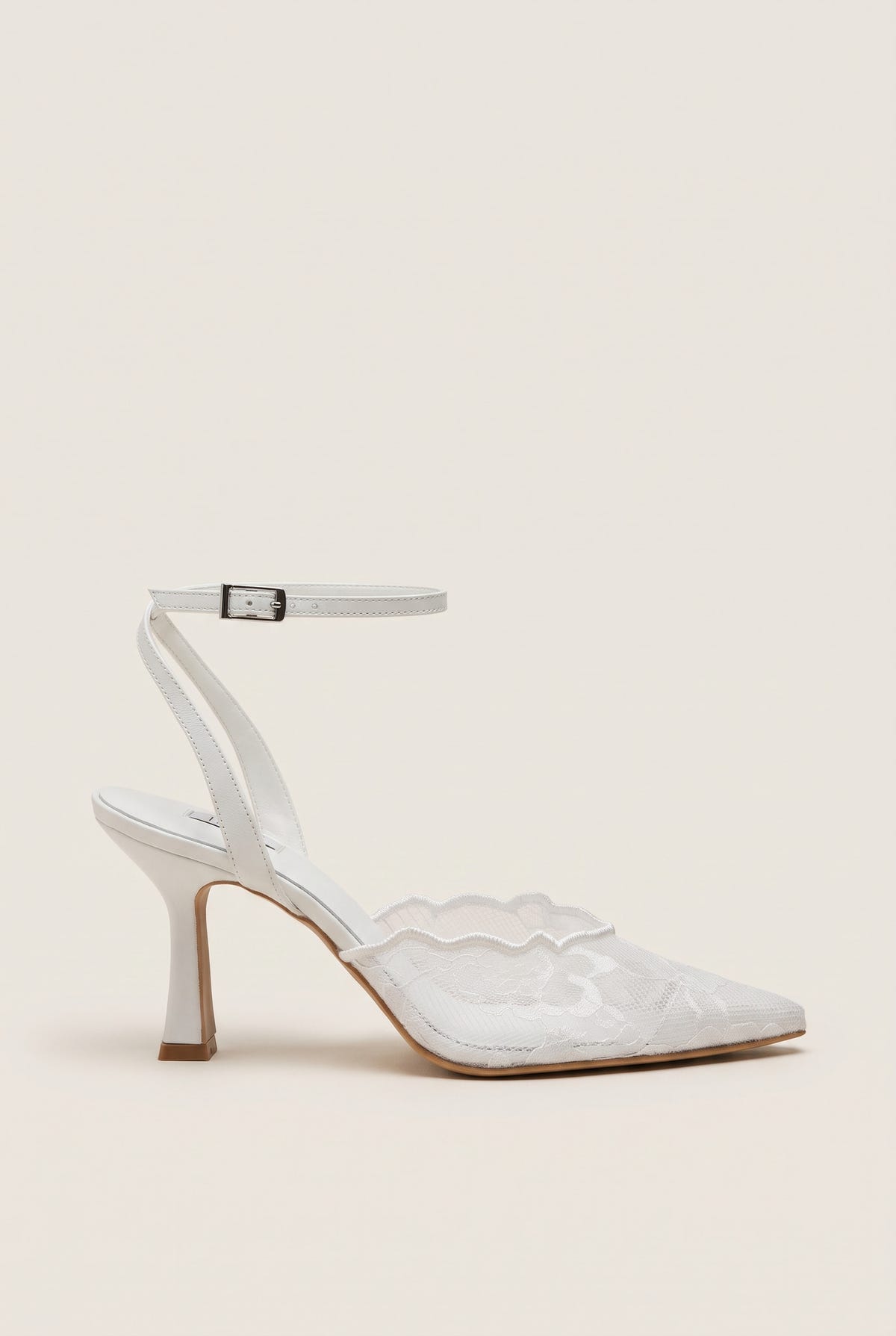 Side view of a white lace pump with a thin ankle strap, buckle closure and a slim stiletto heel
