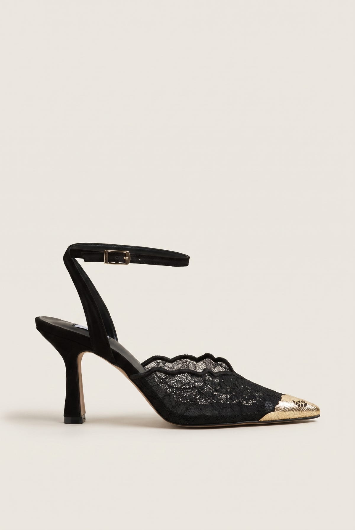 Side view of black lace detail stiletto pump with gold-toned pointed cap toe and ankle strap