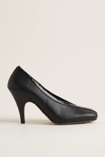 Side view of black leather-look court shoe with V-cut throat, glossy croc-effect trim and a curved high heel