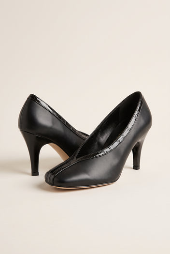 Three-quarter view of a pair of black smooth court shoes with V-cut vamps, croc-effect trim and high heels