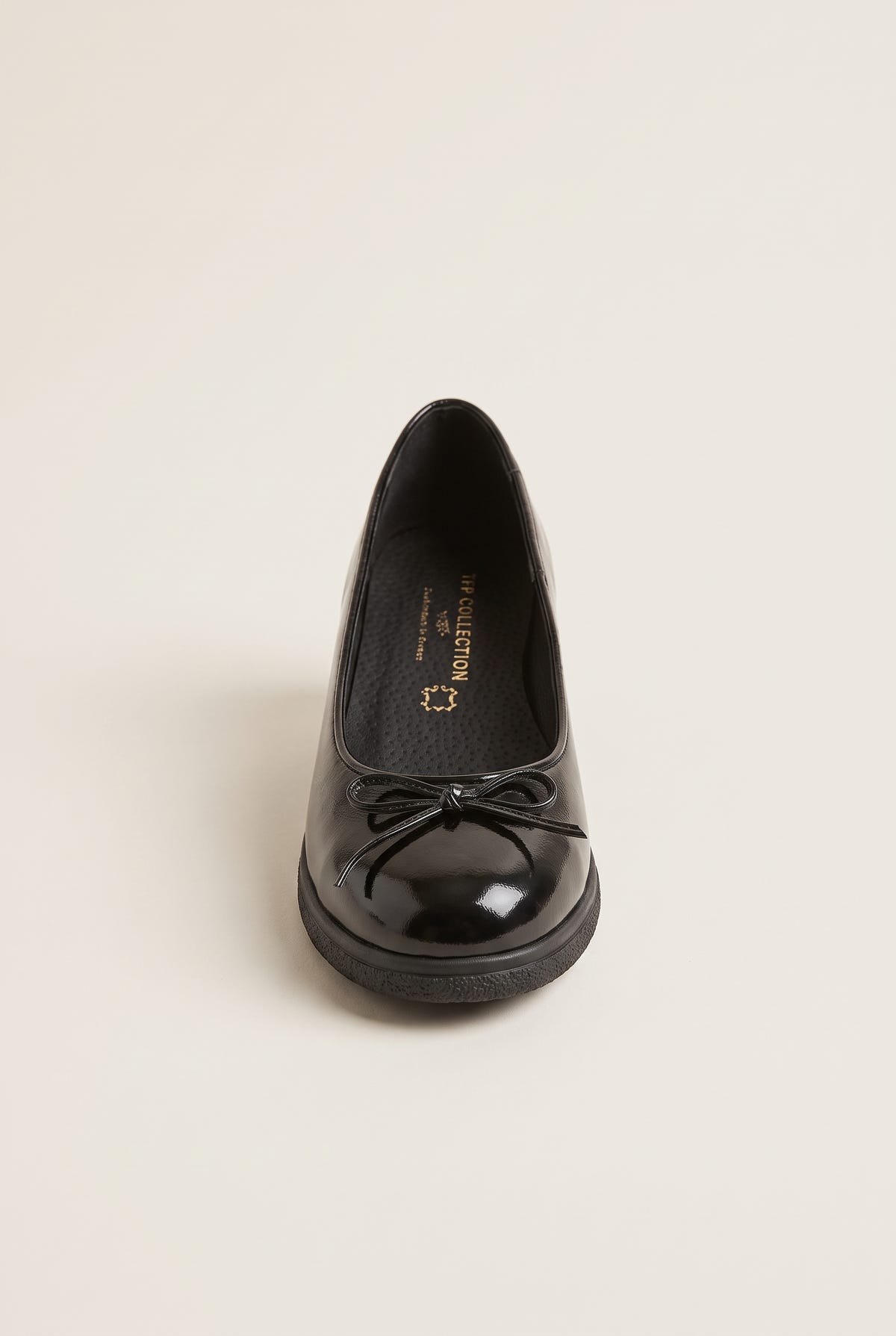 Front view of black patent ballet flat with a small bow over the vamp and round toe